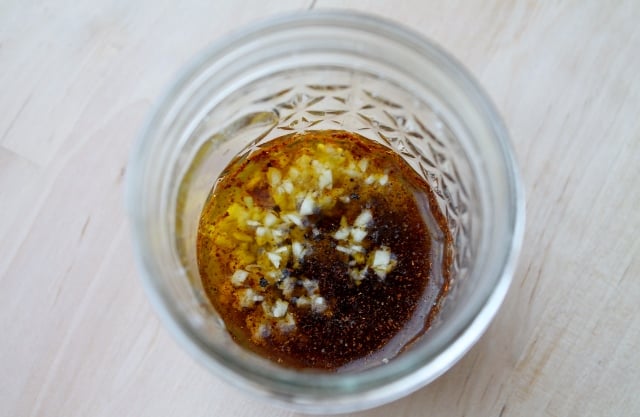 A jar of lime juice with olive oil and chili powder.