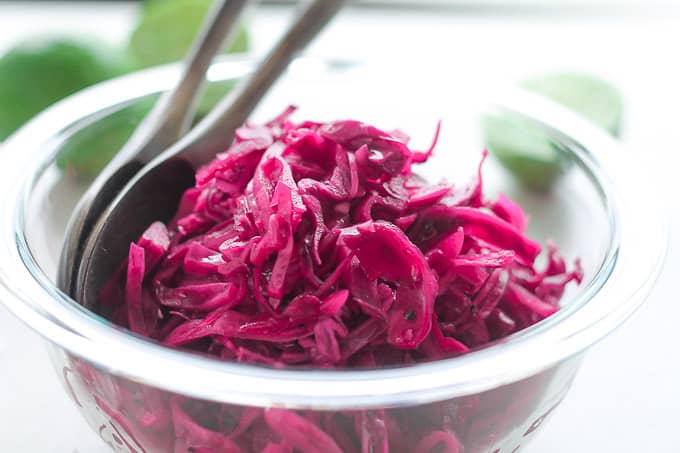 tangy red cabbage slaw with fresh limes in the background