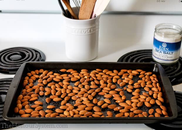 Almonds on a baking sheet sitting on a stovetop
