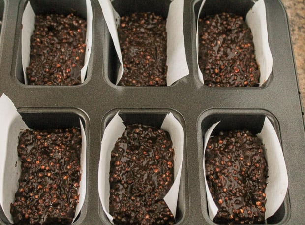 a tin lined with parchment paper filled with crunch bar ingredients