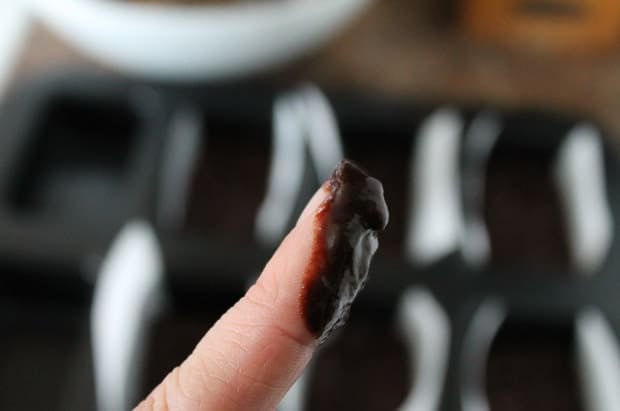 A finger with chocolate on it.
