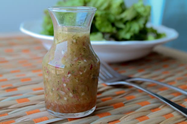 Fresh dressing in a jar with salad greens in the background