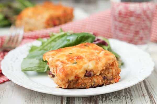 Cheesy casserole on a plate with salad.