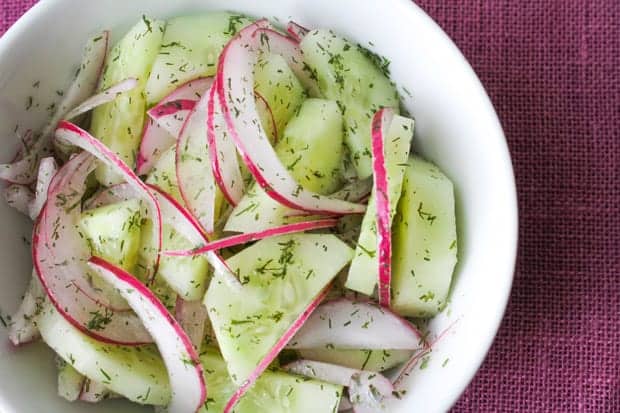 Cucumber Salad with Red Onion + Dill in a white bowl