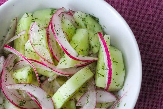 Cucumber Salad with Red Onion + Dill in a white bowl