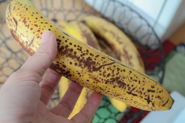 A hand holding a ripe banana