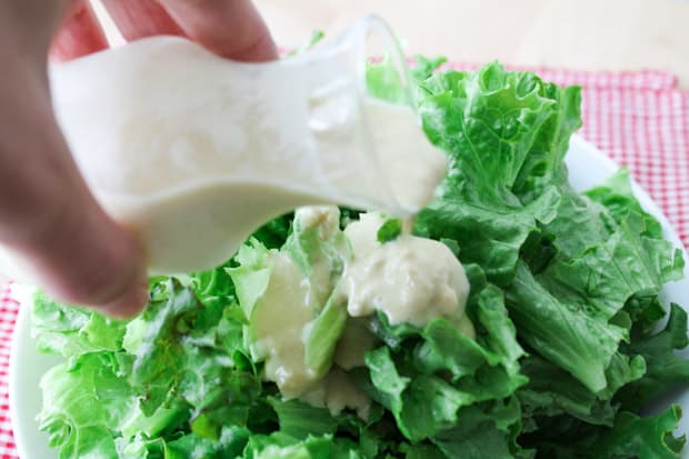 Vegan Caesar Salad Dressing poured over greens