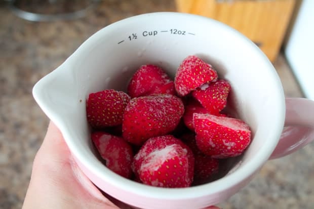 frozen strawberries in a measuring cup