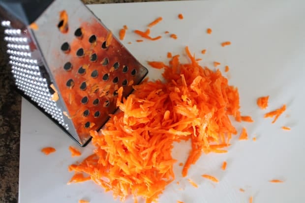 Grated carrots on a white cutting board