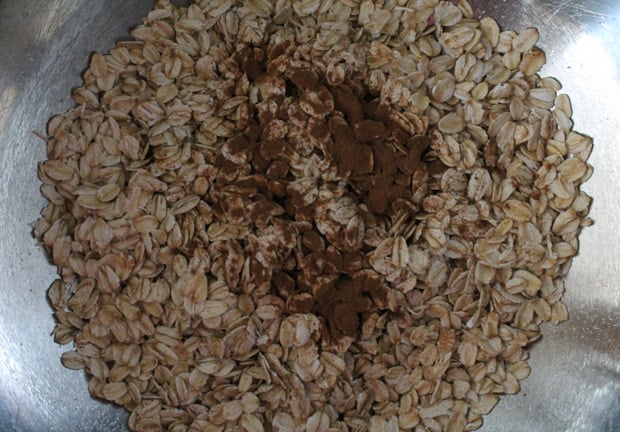a mixing bowl with oats that are sprinkled with cinnamon and salt