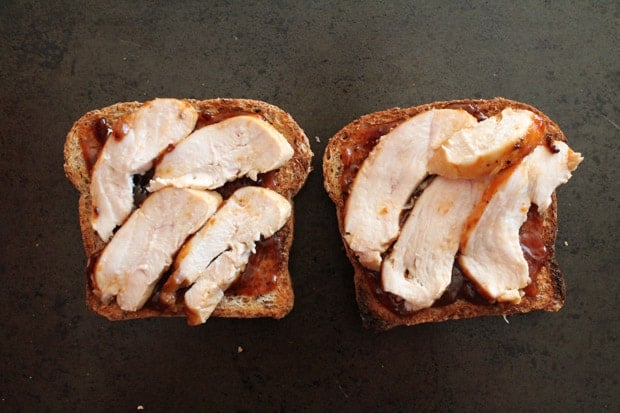 slices of cooked chicken on toasted bread with BBQ sauce