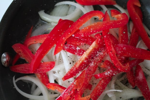 Sliced onions and peppers in a pan