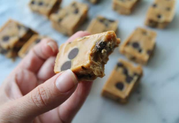 A piece of peanut butter chocolate chip freezer fudge with a bite out of it