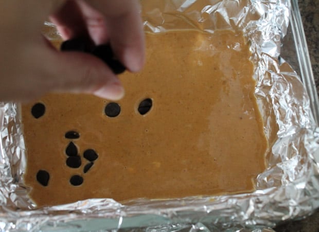Chocolate chips being dropped onto the freezer fudge