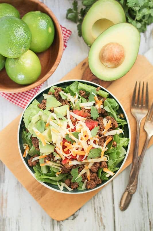 Healthy fresh salad garnished with salsa, cheese and avocado