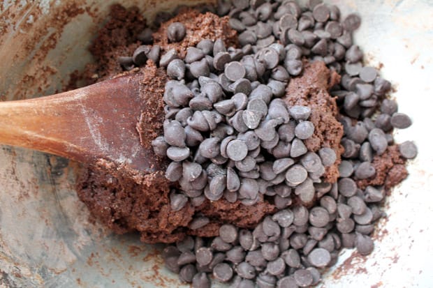 Chocolate chips being stirred into cookie batter 