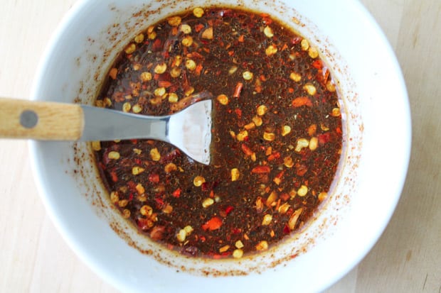 Sauce being stirred by a fork in a white dish