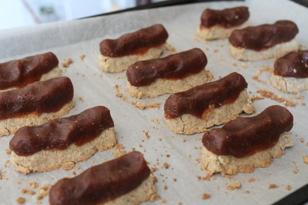 Homemade twix bars on a cookie sheet ready for chocolate coating