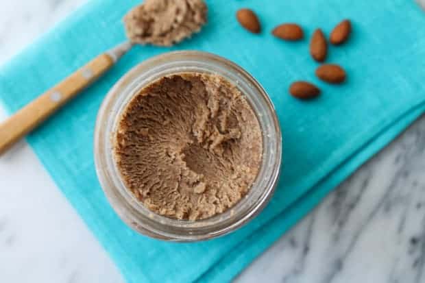 Homemade Maple Almond Butter in a jar sitting on a blue napkin