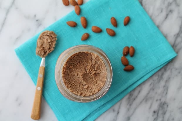 Homemade Maple Almond Butter in a jar sitting on a blue napkin