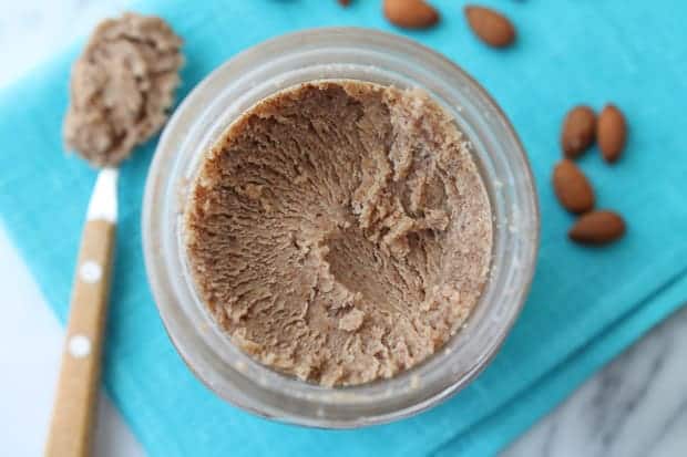 Homemade Maple Almond Butter in a jar sitting on a blue napkin