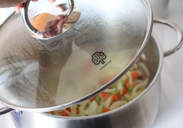 a lid being placed on a soup pot