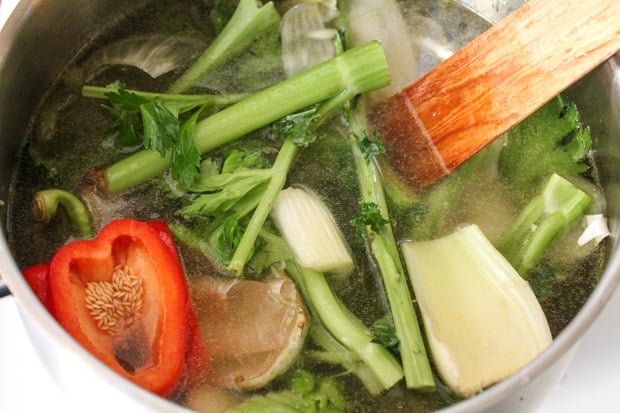 a soup pot full of veggies and water being stirred