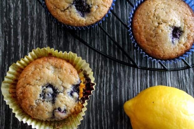 Fresh baked muffins on a wooden surface with a lemon in the background