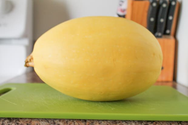 a small spaghetti squash on a cutting board.