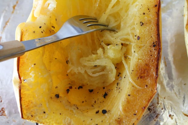 a fork scraping the sides of a roasted vegetable making noodles.