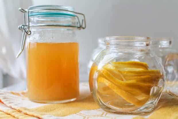 local honey in jar with another glass jar filled with sliced lemons