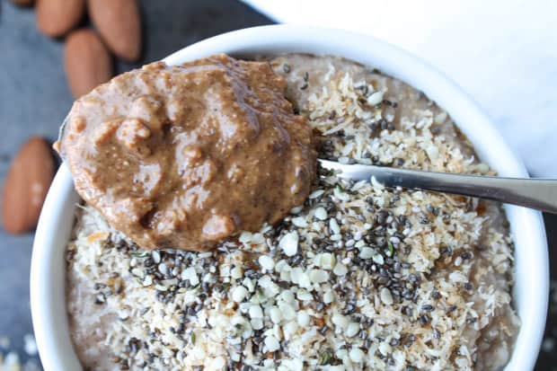 Oat Bran Breakfast Bowl with a spoon full of almond butter on top