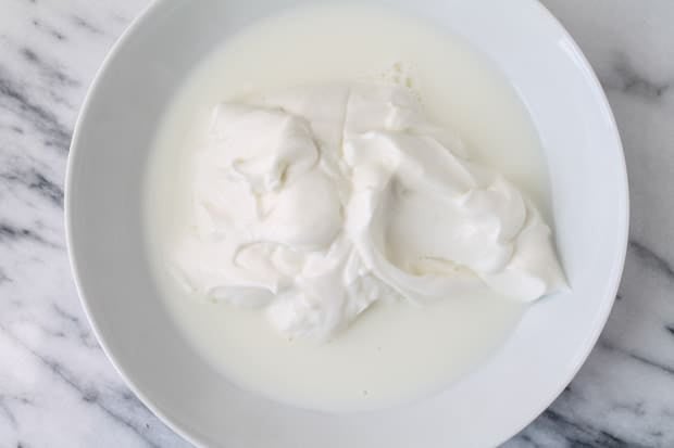 milk and greek yogurt in a white bowl
