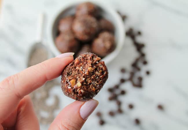 a hand holding a chocolate chia power ball