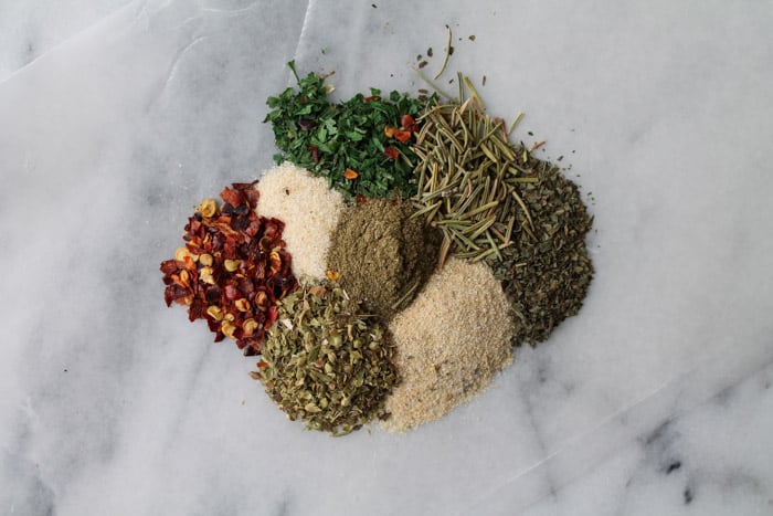 a pile of various spices on a marble counter