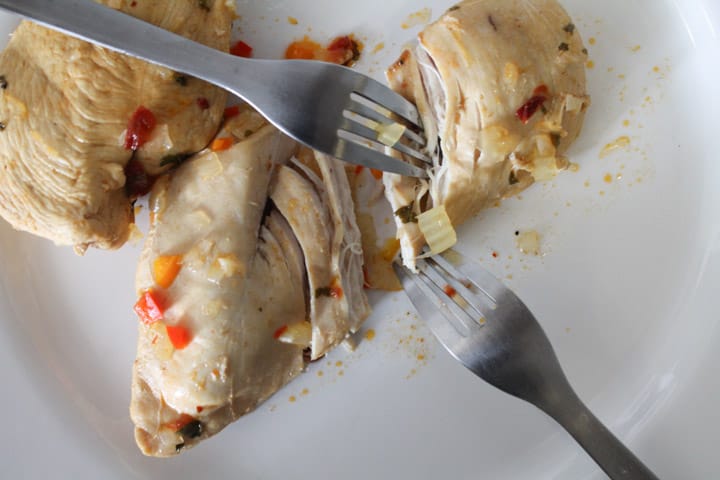 two forks shredding a poached chicken breast