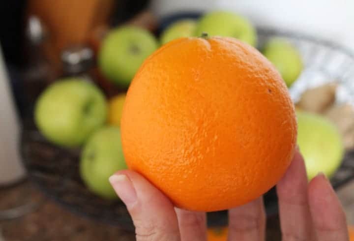 a hand holding an orange.