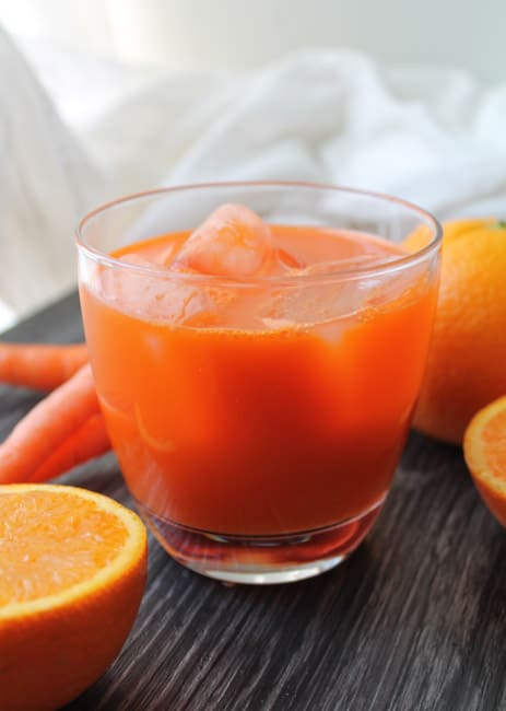 Succo di carota fresco in un bicchiere con ghiaccio