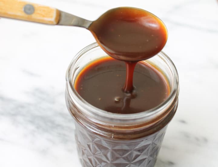 Vegan Salted Caramel Sauce dripping off a spoon.