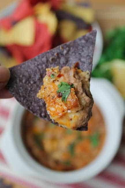 A chip with warm Chipotle Black Bean Dip on it