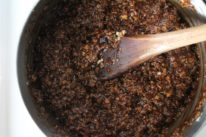 Oats being stirred into the chocolate cookie mixture