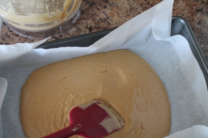 batter being poured in a parchment lined pan