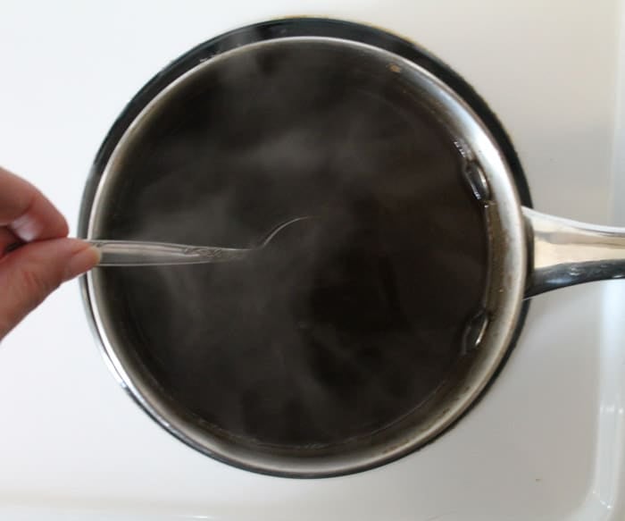 A small saucepan being stirred on a stovetop