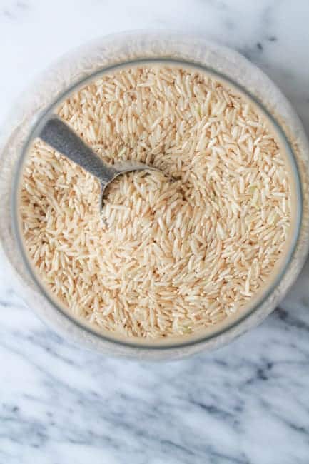 Gluten free brown rice in a jar on a marble counter