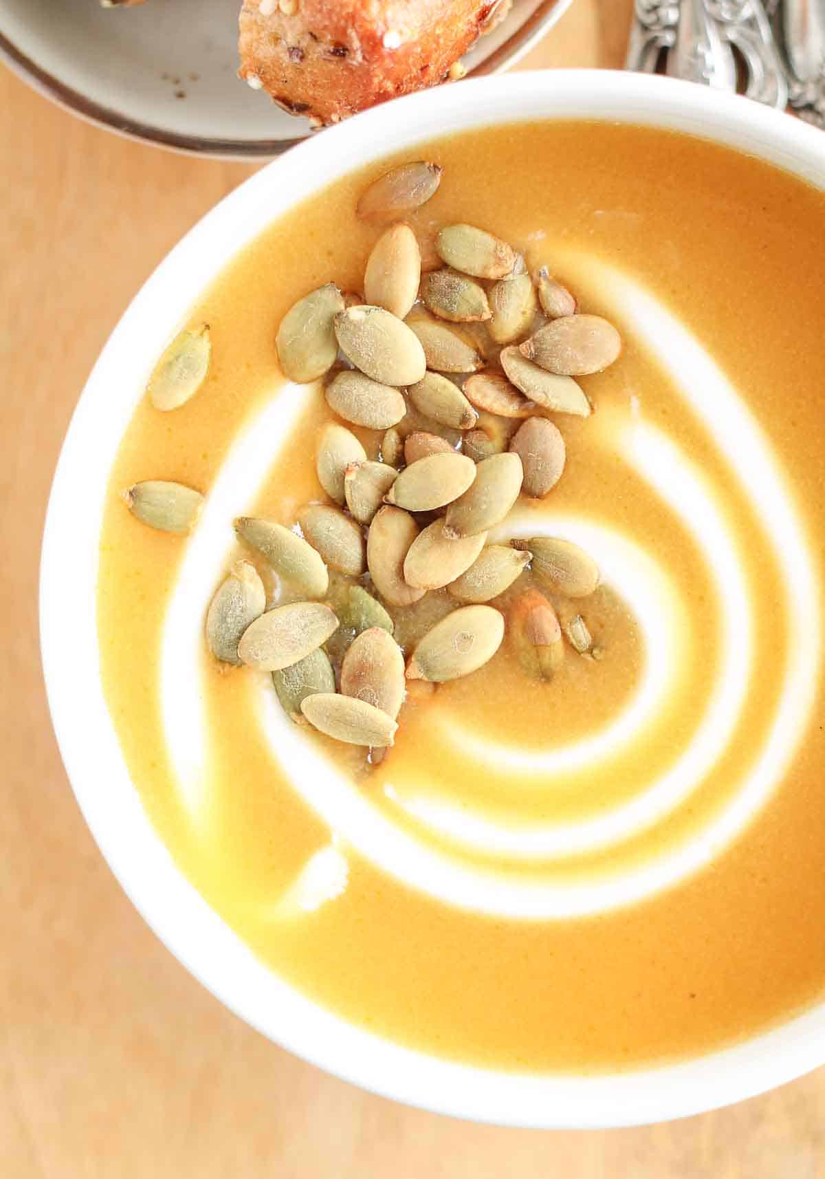 bowl of butternut squash soup garnished with pumpkin seeds