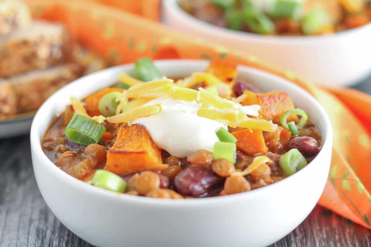 vegetarian lentil chili with roasted butternut squash garnished with green onions