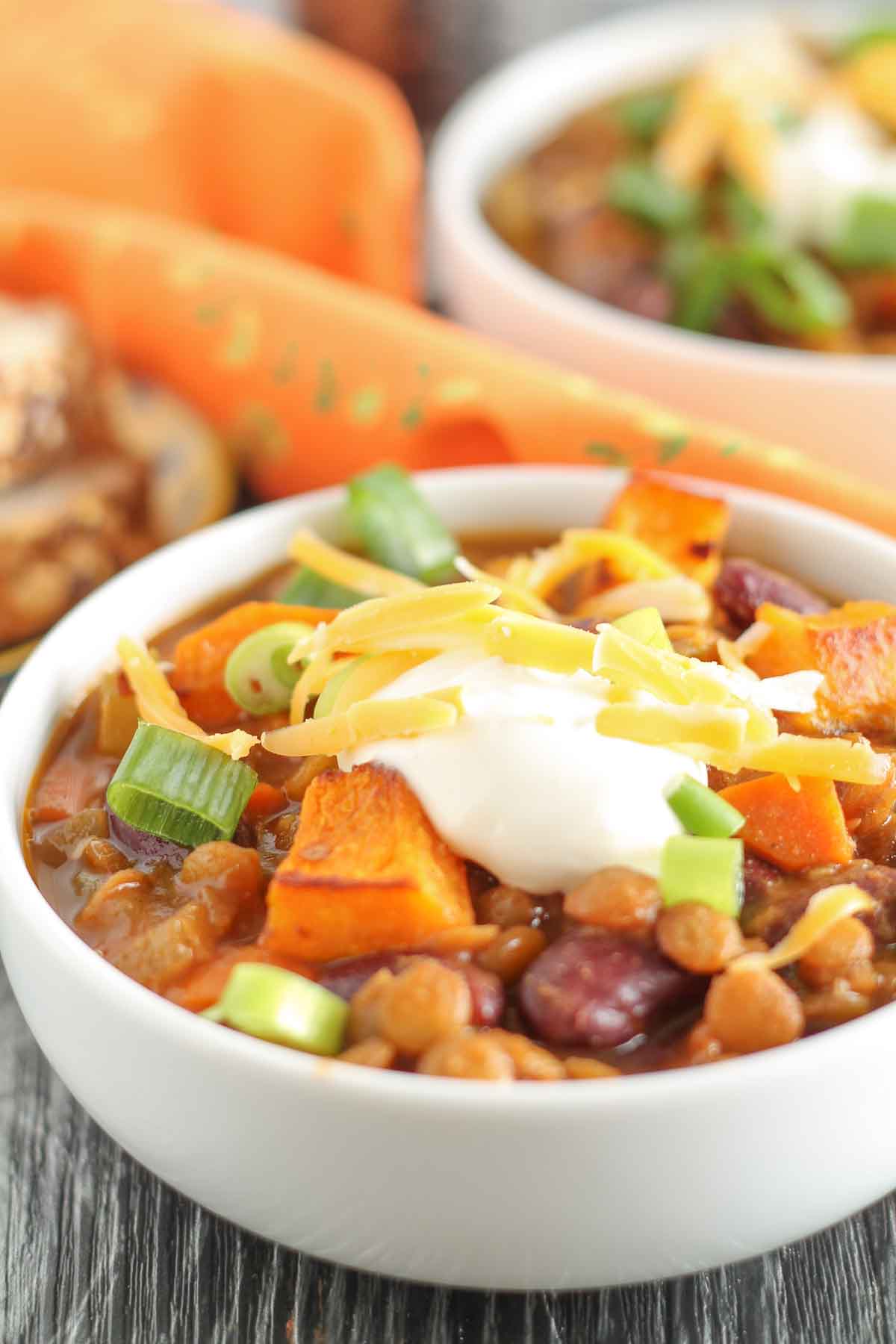 vegan chili with lentils and roasted butternut squash garnished with green onions