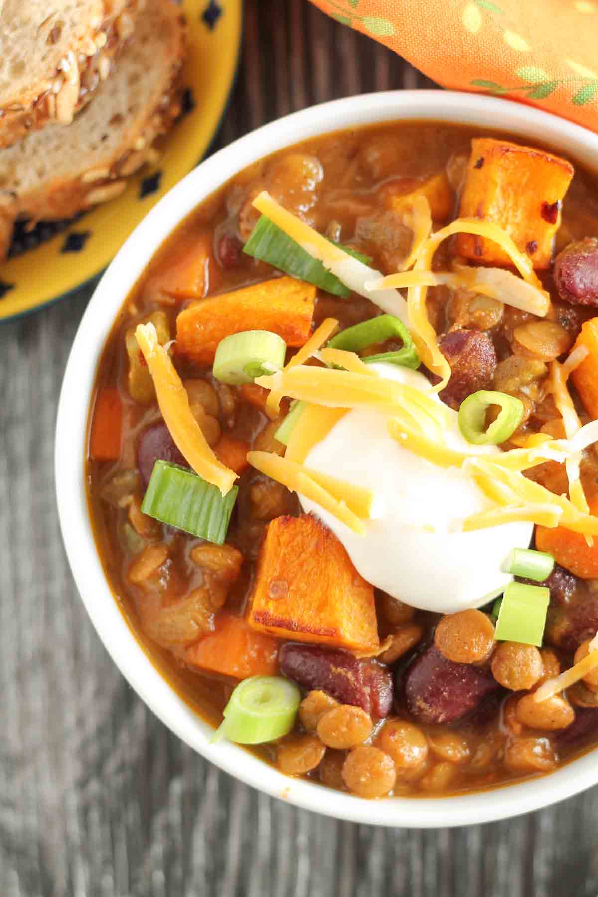 vegetarian lentil chili with roasted butternut squash in a bowl garnished with green onions