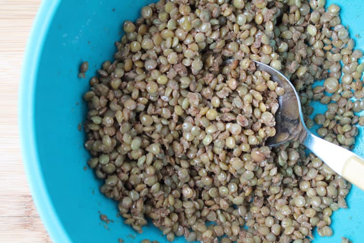 Lentils being stirred in a blue bowl