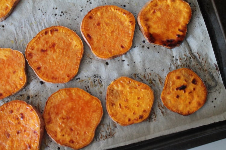 roasted sweet potatoes on a parchment lined baking sheet